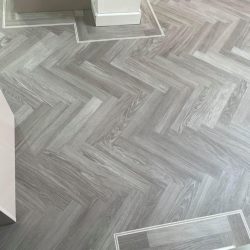 Light grey herringbone flooring with a border fitted in a house in Consett