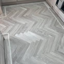 Light grey herringbone flooring with a border fitted in a kitchen in Consett