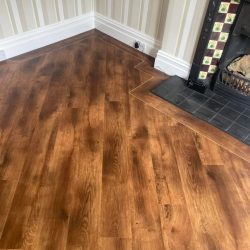 Dark wood effect LVT Flooring with a border fitted in a lounge in Consett